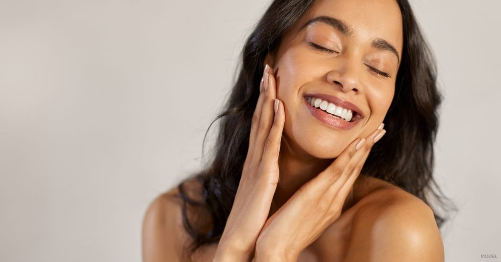 Woman (model) smiling and enjoying her long-lasting skin care results.